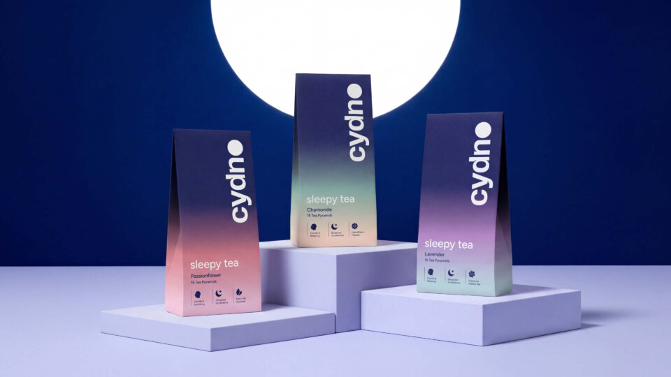 Three tapered Cydno sleepy tea cartons — Passionflower, Chamomile, Lavender — on lilac plinths under a full moon